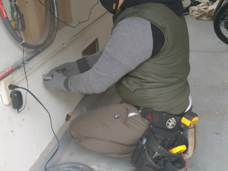 Electrician performing outlet wiring in a Coopersville garage